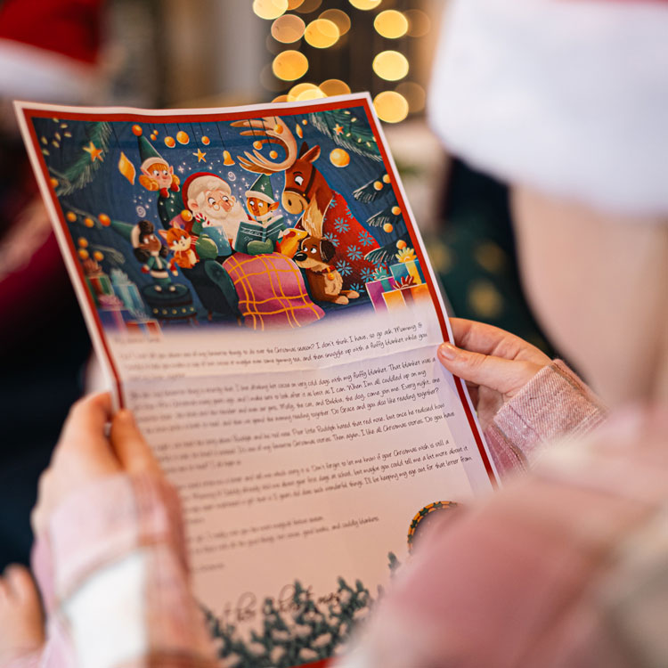 A child holding a letter from Santa focused